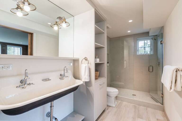 The bunk room features a ensuite bathroom with tiled shower and large farmers sink.