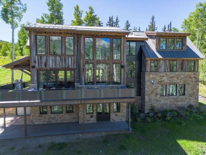 This multi-level luxurious home features two private deck areas, floor-to-ceiling windows, a private hot tub, and expansive green space, offering the perfect blend of comfort and elegance.