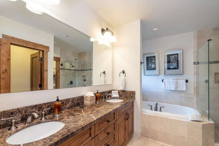 The Primary en suite bathroom has a Large vanity for two, with a jetted tub and a beautiful connecting shower.