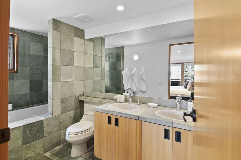 The ensuite bathroom features a shower/tub combo and his and hers vanity.