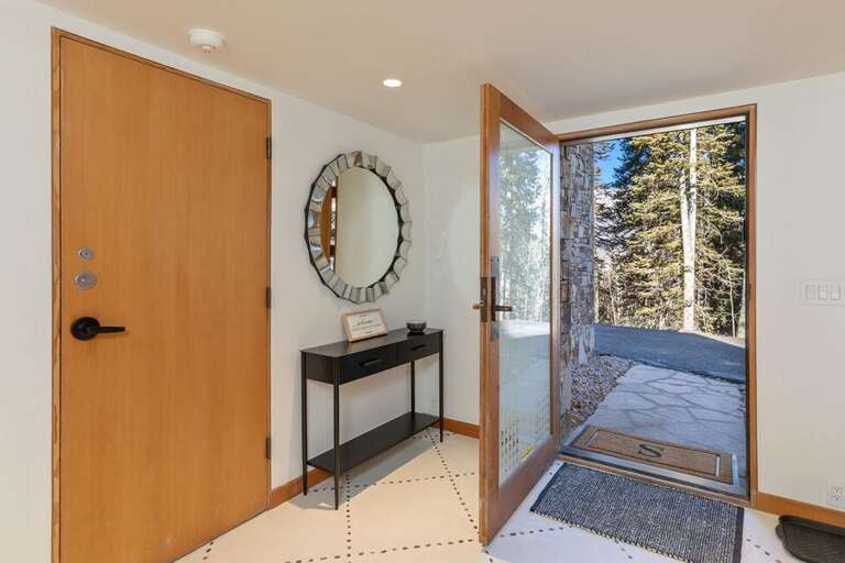 The entry way can be accessed via the entry door as well as the garage .