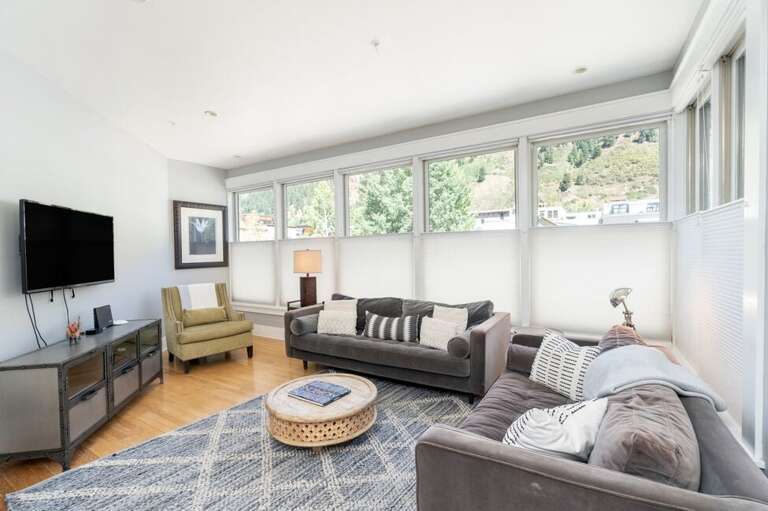 Bright open-concept living area with oversized windows and incredible mountain views.