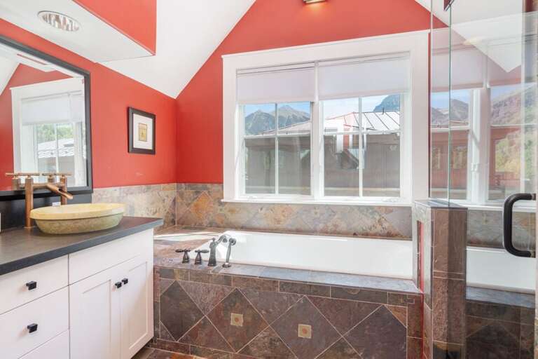 The ensuite bathroom offers a spa-like experience with a deep soaking tub and a modern step-in shower.