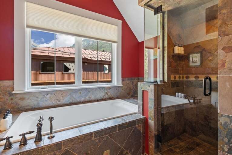 The ensuite bathroom offers a spa-like experience with a deep soaking tub and a modern step-in shower.