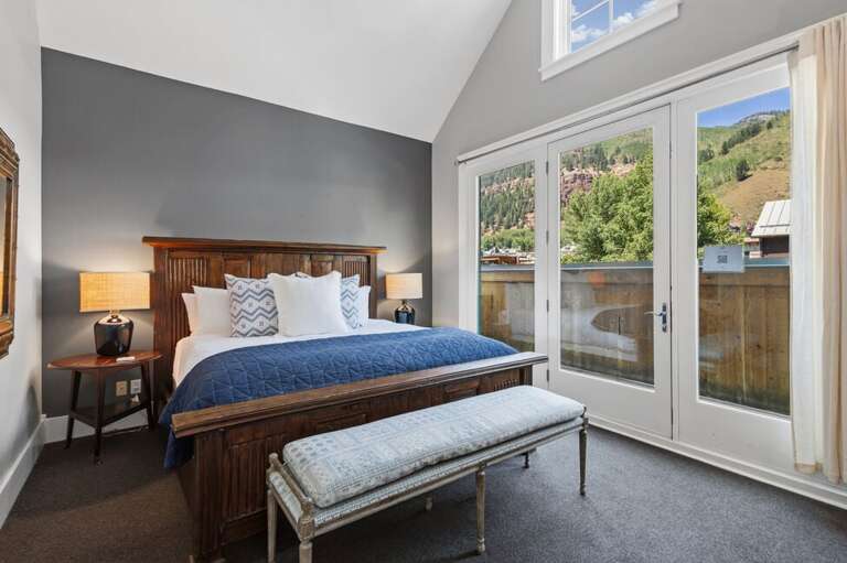 The spacious primary suite features a comfortable king bed and a private balcony with beautiful mountain views.