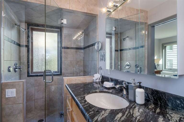 Primary en suite bathroom with shower only and large single sink vanity.