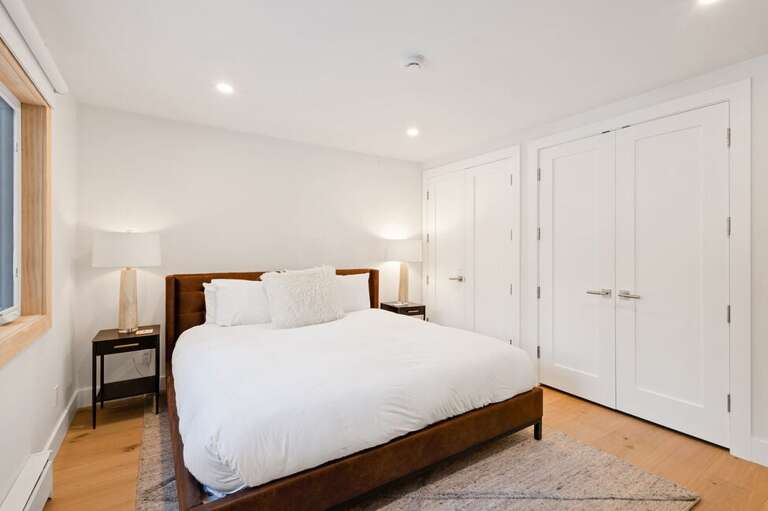Primary kind bedroom with ensuite bathroom, large dresser and spacious closets.