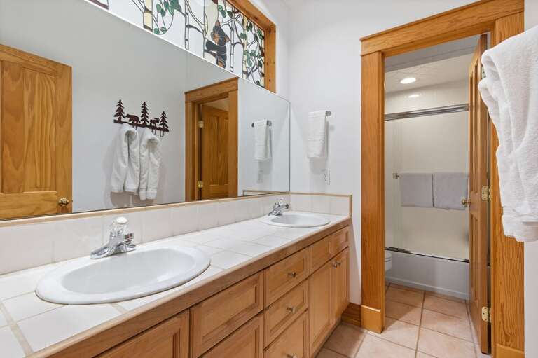 The second floor shared bathroom provides a double vanity, and shower/tub combo