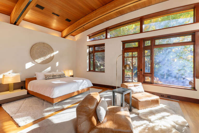 Primary Suite: A serene sanctuary with king bed, a flat-screen TV, and fireplace.