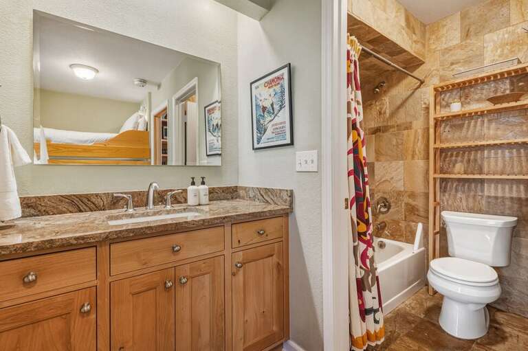 The bathroom features a separate vanity area, with the shower and toilet in a private, enclosed space—perfect for added privacy and easy sharing.