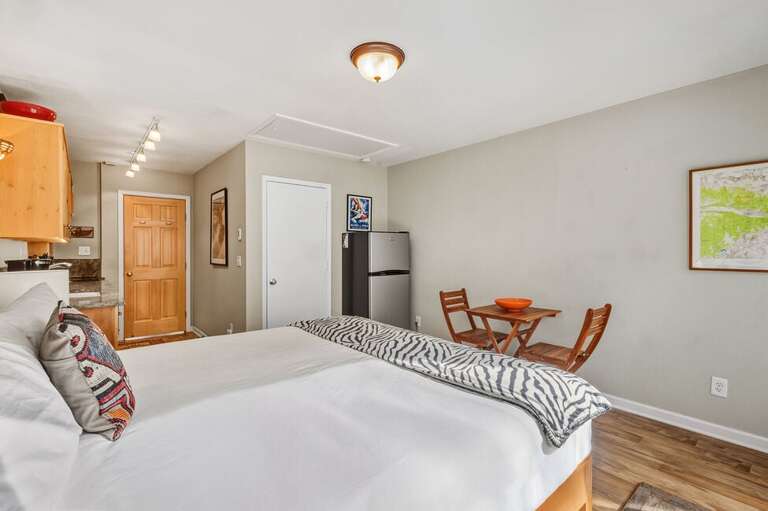 The primary bedroom and cozy galley kitchen share a same space that opens into a beautiful private deck.