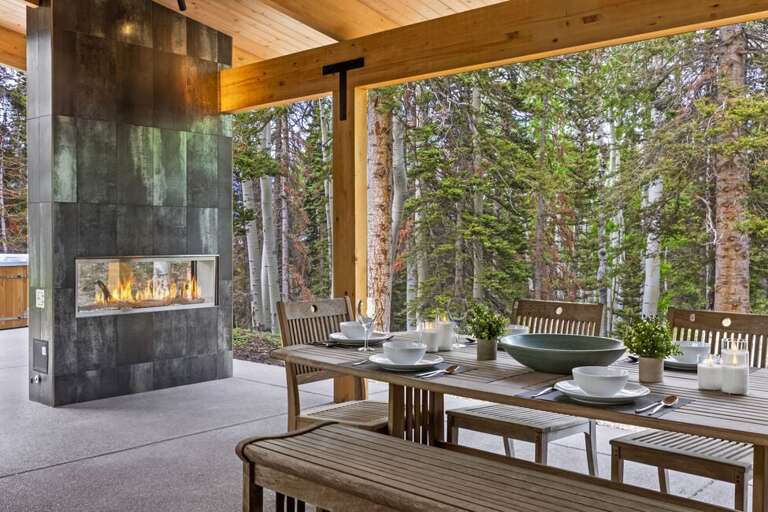 Outdoor dining/grilling area with hot tub and gas fireplace.