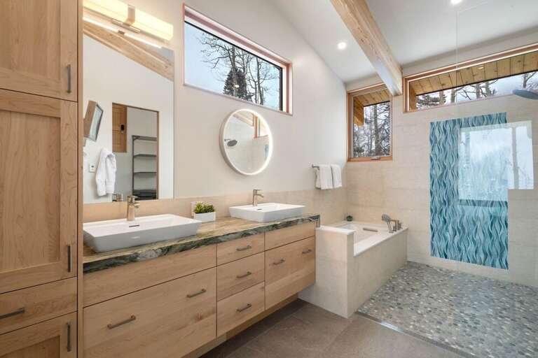 The primary ensuite luxury bathroom features: soaking tub-rain shower, double Vanity and water closet.