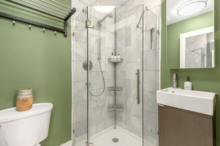Bathroom features a step in shower and vanity.