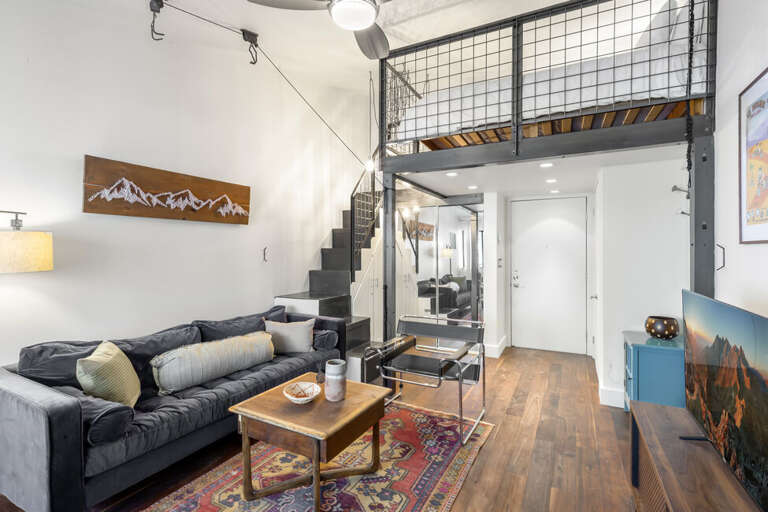 Spacious studio with Queen bed, closet for storage, high ceilings, and modern style.