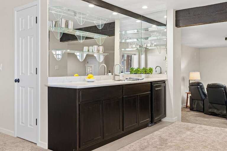 This level features a full bar area with mini fridge and sink.