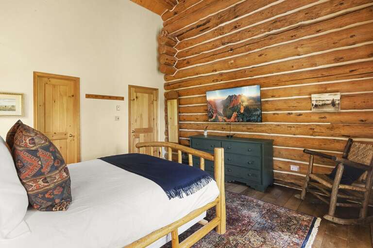 Beautiful guest room on the main level gives the cozy cabin vibe with stunning views.