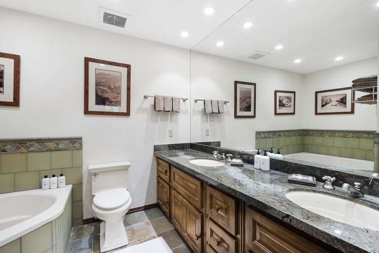Shared bathroom features double vanity, soaking tub and steam shower.