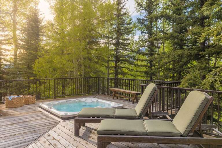 Stunning deck area with hot tub and lounge seating.