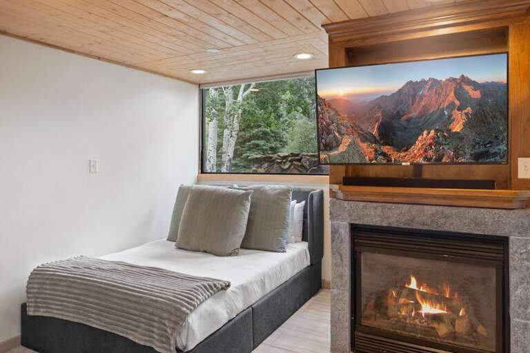 Bright and inviting studio featuring a Queen bed, cozy fireplace, and mountain views through large picture windows.