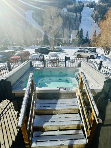 Outdoor hot tub area offers stunning views of the ski runs and surrounding mountains.