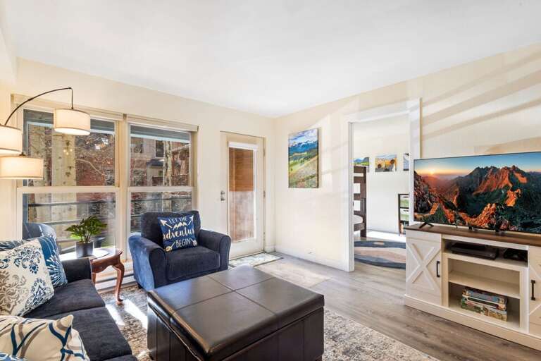 A bright and inviting living room featuring cozy seating, large windows with natural light, and ample space for the whole family to be together.