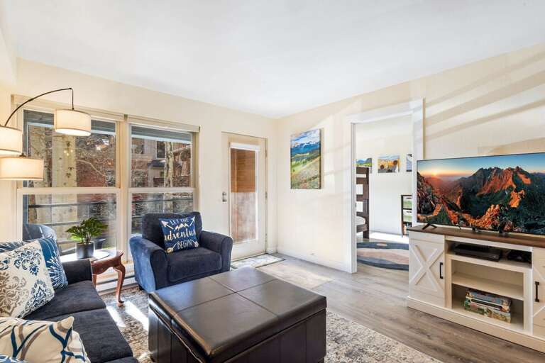 A bright and inviting living room featuring cozy seating, large windows with natural light, and ample space for the whole family to be together.