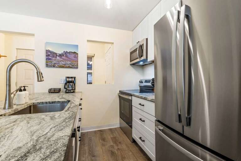 Cook and connect in this newly renovated kitchen with sleek stainless steel appliances and cozy island seating for two.
