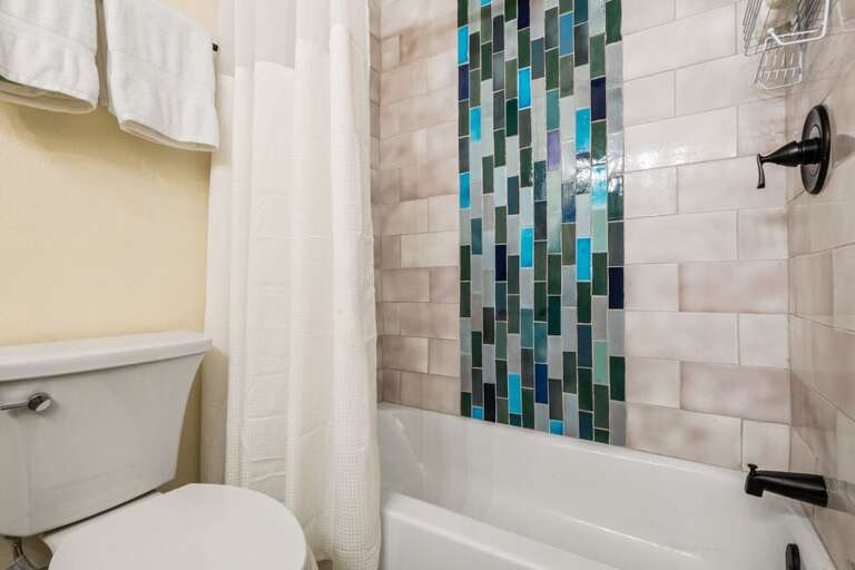 Single bathroom features step in tub/shower condo with single vanity.