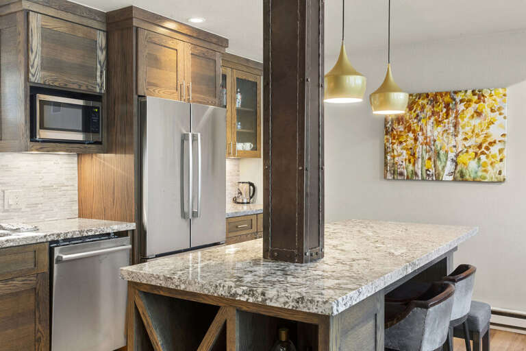 A bright open kitchen with a gas stove, double-door fridge, dishwasher, and microwave, offering ample counter space and modern style — perfect for the chef in you.