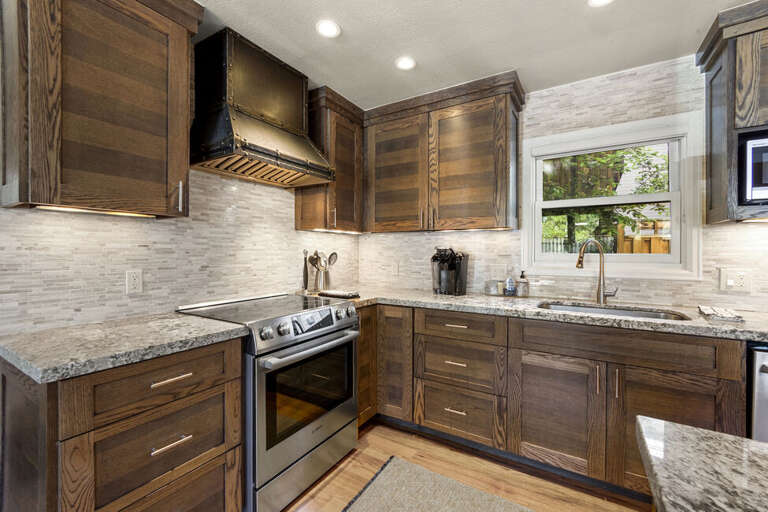 A bright open kitchen with a gas stove, double-door fridge, dishwasher, and microwave, offering ample counter space and modern style — perfect for the chef in you.