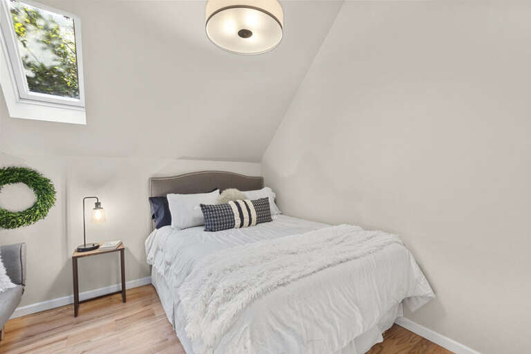 This cute comfortable guest bedroom features skylights that allow ample natural light.