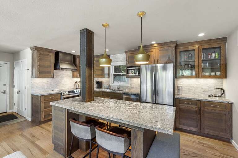 Spacious kitchen with stainless appliances, large kitchen island with seating for four.