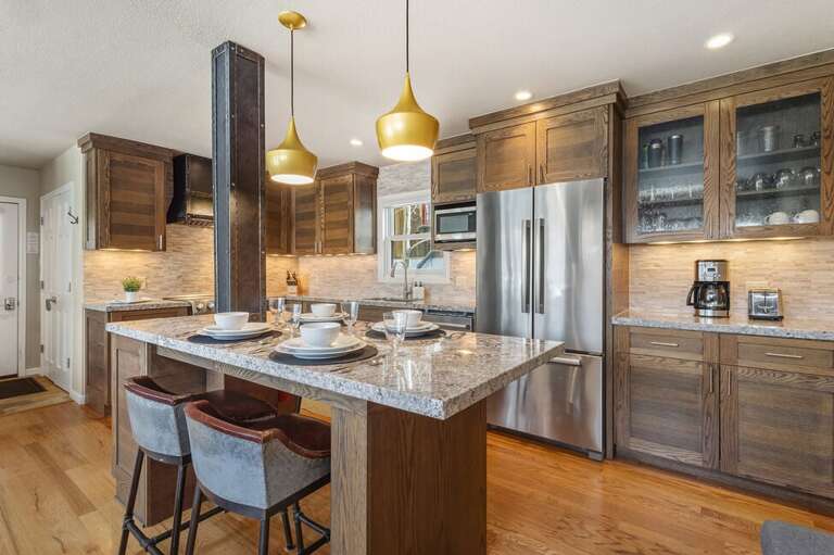 Spacious kitchen with stainless appliances, large kitchen island with seating for four.