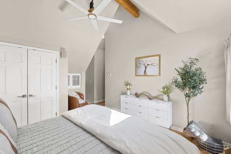 A spacious primary bedroom featuring a king bed, abundant natural light, an ensuite bathroom, and a large closet.