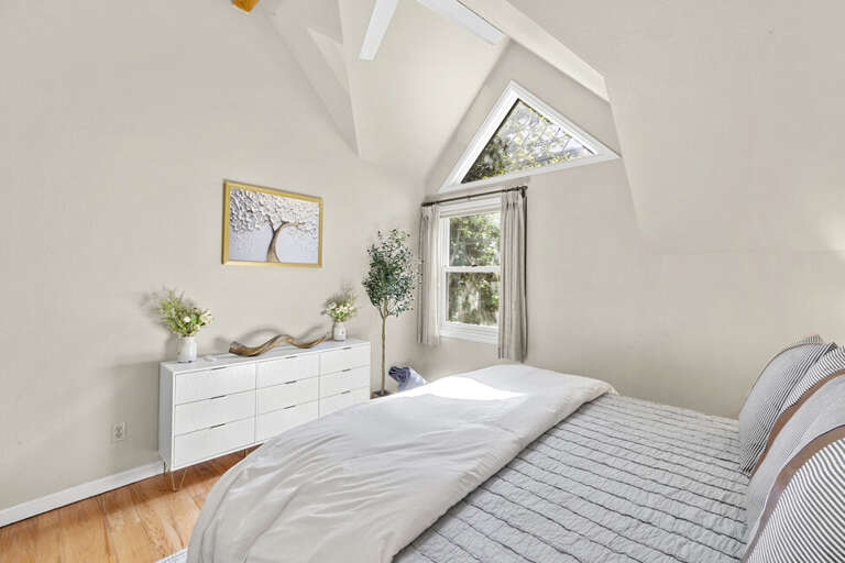 A spacious primary bedroom featuring a king bed, abundant natural light, an ensuite bathroom, and a large closet.