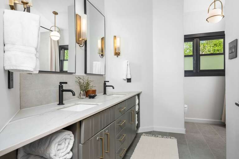 Shared bathroom with separate vanity and bathroom features stepping tub/shower combo.