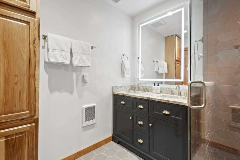 Ensuite primary bathroom with double vanity and step in shower.