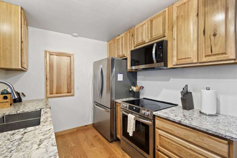 Features gas stove microwave and refrigerator.
