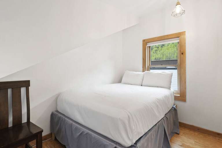 Second guest room features queen bed and single bed for extra guests.