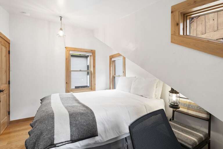 Guest room with queen bed and desk area.