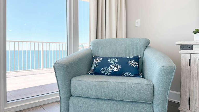 Blue Chair Beside Balcony Overlooking Sea In Vacation Rental