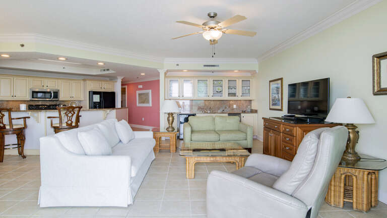 Interior Living Space With White Sofas, Wooden Furniture, And Kitchenette