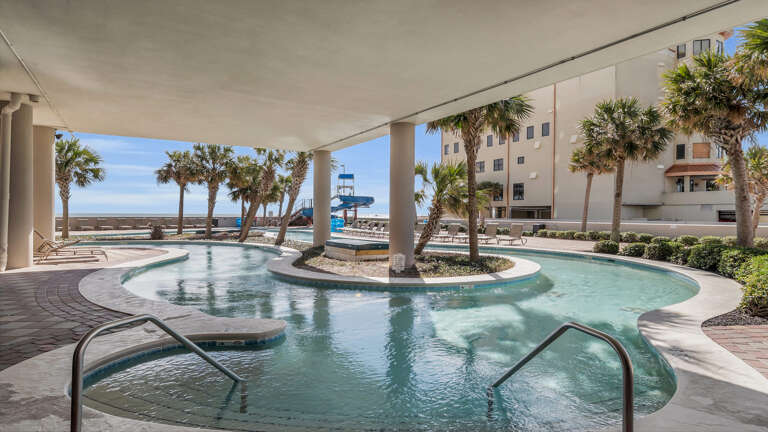 Outdoor Pool Area With Palm Trees And View Of The Ocean