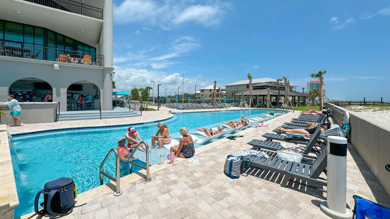 Poolside Area With Lounging Guests At A Vacation Rental