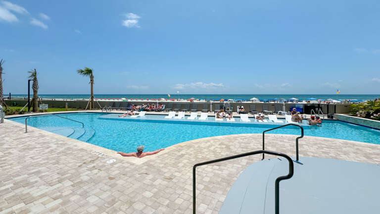 Swimming Pool With Sun Loungers And Ocean View