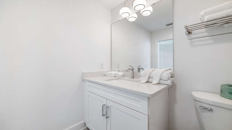 White Walls Washroom With Bright Bulb Brilliance, Reflecting Simple Sink Setup