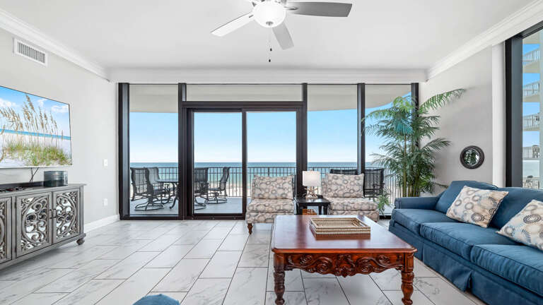 Bright Beachfront Room With Balcony Doors, Blue Sofa, And Sea View