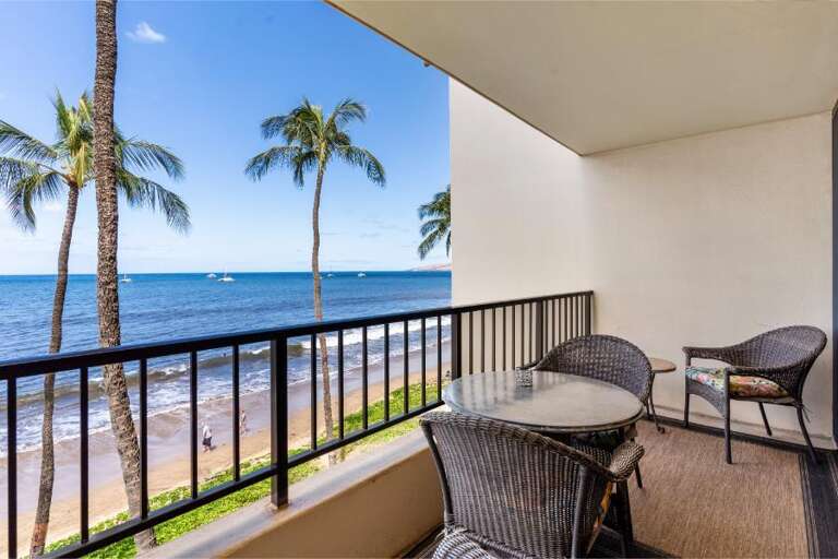Balcony View Of Palm Trees And Ocean With Chairs And Railing