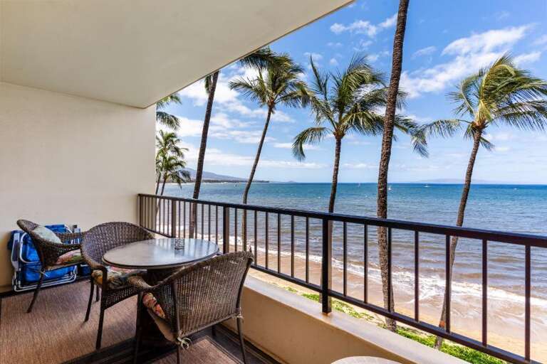 Balcony View Of Beach With Palms, Railings, And Seating